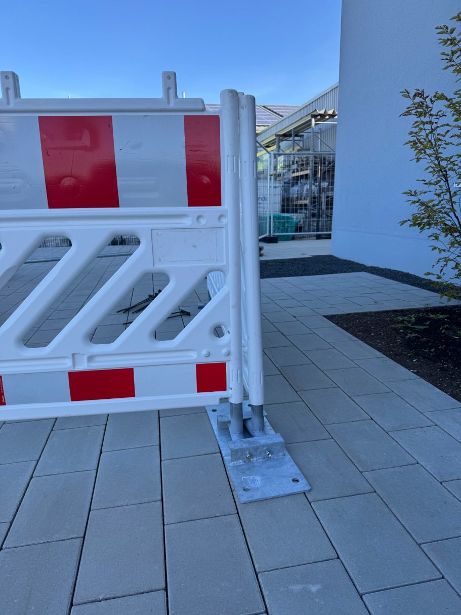 Baufreigabe mit rot-weißer Schranke und klaren Sichtlinien in einem Innenhof.